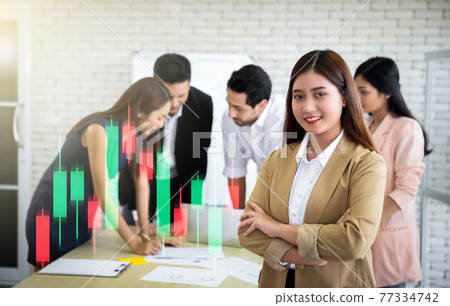 portrait of businesswoman with team meeting on background with candlestick graph portrait of businesswoman with team meeting on background with candlestick graph 77334742