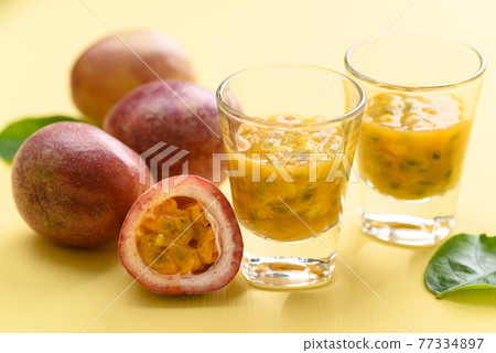 Fresh passion fruit juice in glass on yellow background 77334897
