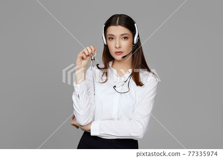 caucasian woman with headset on gray background caucasian woman with headset on gray background 77335974