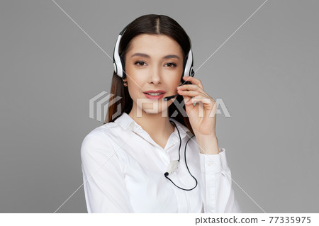 caucasian woman with headset on gray background caucasian woman with headset on gray background 77335975