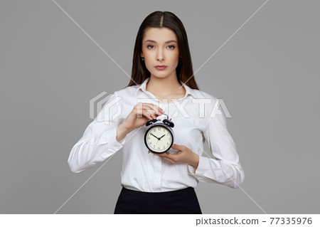 beautiful caucasian business woman holding alarm clock 77335976