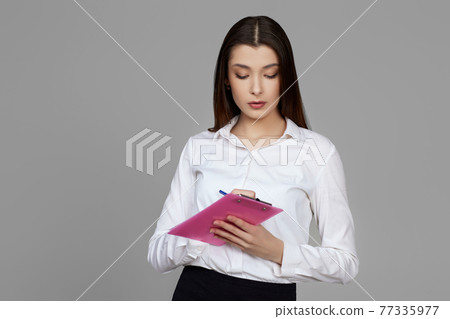 young woman holding clipboard with papers document young woman holding clipboard with papers document 77335977