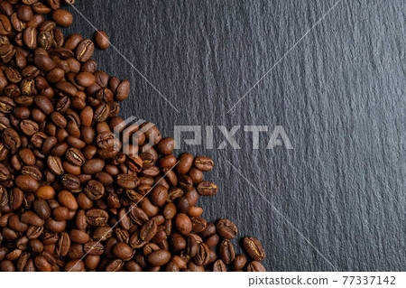 A lot of coffee beans laid out on slate with place for copy space. Top view. 77337142