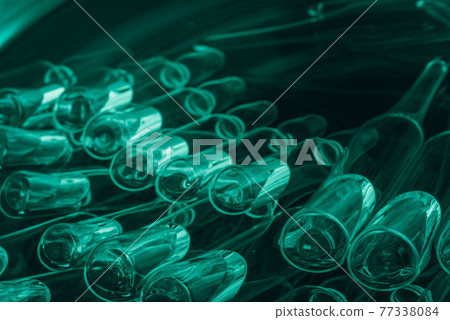 Glass medical ampoule vial for injection. Medicine is liquid sodium chloride with of aqueous solution in ampulla. Close up. Bottles ampule multicolor. 77338084