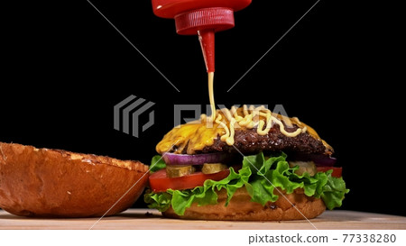 Craft burger is cooking on black background. Consist: sauce, lettuce, tomato, red onion, pickle, cheese, bacon, air bun and marbled meat beef. Craft burger is cooking on black background. Consist: sauce, lettuce, tomato, red onion, pickle, cheese, bacon, air bun and marbled meat beef. 77338280