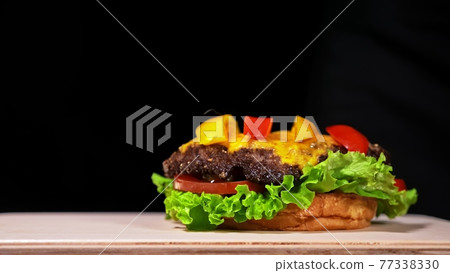 Craft burger is cooking. Consist: red sauce salsa, lettuce, red onion, pickle, cheese, chilli green pepper, air bun and marbled meat beef. Craft burger is cooking. Consist: red sauce salsa, lettuce, red onion, pickle, cheese, chilli green pepper, air bun and marbled meat beef. 77338330