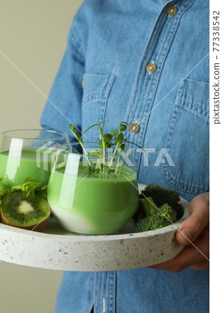 Woman hold tray with glasses of smoothie and ingredients 77338542