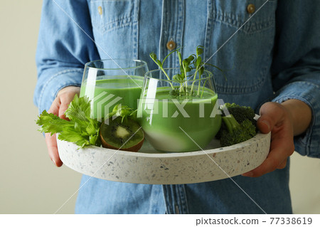 Woman hold tray with glasses of smoothie and ingredients 77338619