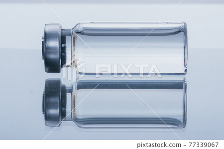 Glass medical ampoule vial for injection. Medicine is dry white drug penicillin powder or liquid with of aqueous solution in ampulla. Close up. 77339067
