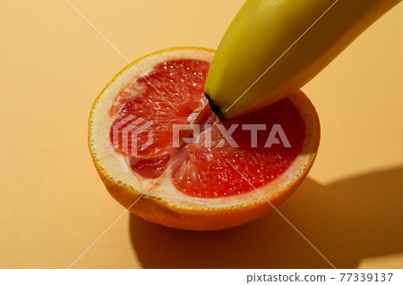Banana and grapefruit on beige background, close up Banana and grapefruit on beige background, close up 77339137