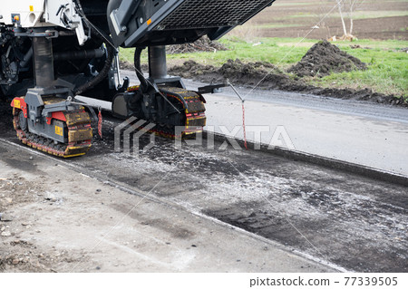 repair of an asphalt road with fresh asphalt 77339505