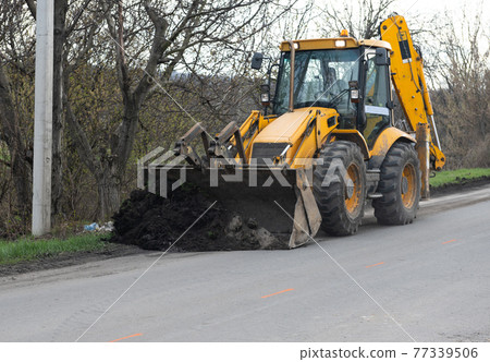 excavator works on road repair 77339506