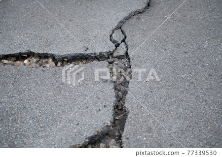 asphalt road in need of repair 77339530
