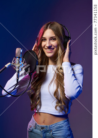 Girl blogger recording audio podcast. 77341158