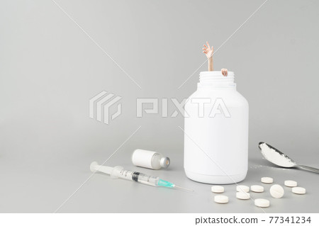 Stop drug addiction. Drug addict hands try to coming out of the pills bottle on gray background. Creative idea for support to help in drug rehabilitation. International Day against Drug Abuse concept. 77341234