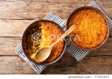 Pastel de choclo corn pie is a Chilean dish based on sweetcorn and beef closeup in the pots. Horizontal top view Pastel de choclo corn pie is a Chilean dish based on sweetcorn and beef closeup in the pots. Horizontal top view 77341837