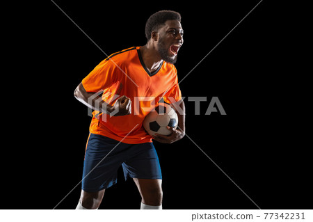 Portrait of young African soccer player posing isolated on black background. Concept of sport. 77342231