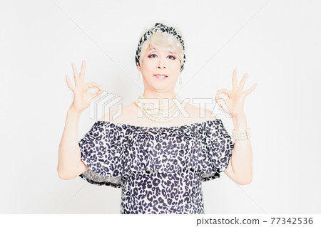 Drag queen standing in front of a white background and making an OK gesture Drag queen standing in front of a white background and making an OK gesture 77342536