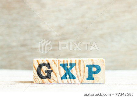 Alphabet letter block in word GXP on wood background 77342595