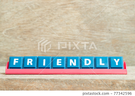 Tile alphabet letter with word friendly in red color rack on wood background Tile alphabet letter with word friendly in red color rack on wood background 77342596