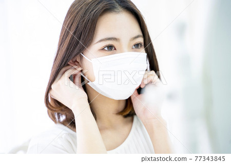 A woman wearing a mask A woman wearing a mask 77343845
