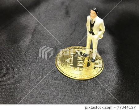 Image of office worker, virtual currency, speculation, winner standing on Bitcoin Image of office worker, virtual currency, speculation, winner standing on Bitcoin 77344157