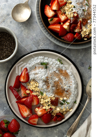 Chia seed pudding bowls with strawberries and oats. Healthy food breakfast, top view. Food scene. 77344552
