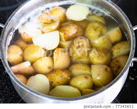 young potatoes are cooked in steel pan 77345651