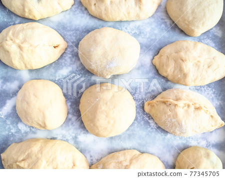 raw handmade sweet buns on baking paper raw handmade sweet buns on baking paper 77345705