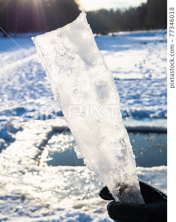 hand holds ice block illuminated by sun in winter hand holds ice block illuminated by sun in winter 77346018
