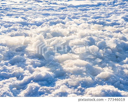 sunlit ice blocks on snow-covered frozen river sunlit ice blocks on snow-covered frozen river 77346019