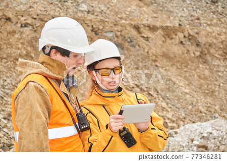 mining engineers discussing working documentation at the mining site mining engineers discussing working documentation at the mining site 77346281
