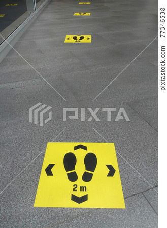 Keep distance sign printed on the floor, safety sticker on ground during Coronavirus COVID-19 outbreak, social distancing in a public area to prevent spreading virus disease infection Keep distance sign printed on the floor, safety sticker on ground during Coronavirus COVID-19 outbreak, social distancing in a public area to prevent spreading virus disease infection 77346538