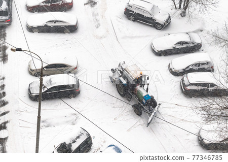 road cleaning in parking area with tractor in snow road cleaning in parking area with tractor in snow 77346785