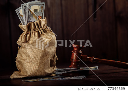 Dollar money bag and judge's gavel. Litigation, dispute resolution, conflict of interest settlement 77346869