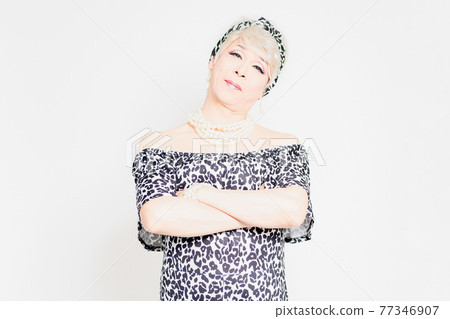 Drag queen standing in front of a white background and folding her arms Drag queen standing in front of a white background and folding her arms 77346907