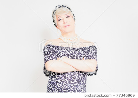 Drag queen standing in front of a white background and folding her arms Drag queen standing in front of a white background and folding her arms 77346909