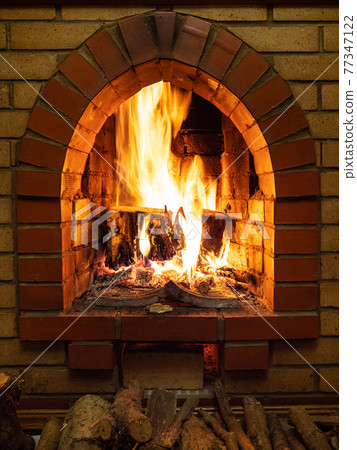 front view of fireplace with fire and firewood front view of fireplace with fire and firewood 77347122