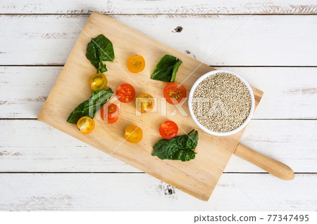 Quinoa, tomatoes and spinach on white wooden table 77347495