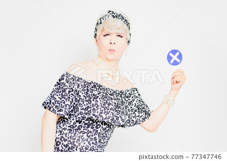 Drag queen with NG placard standing in front of white background Drag queen with NG placard standing in front of white background 77347746