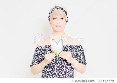 Drag queen with a beginner mark standing in front of a white background 77347776