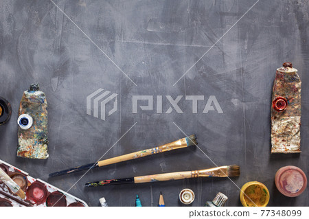 Used paintbrush and tubes with painter tools at abstract table background texture. Used paintbrush and tubes with painter tools at abstract table background texture. 77348099
