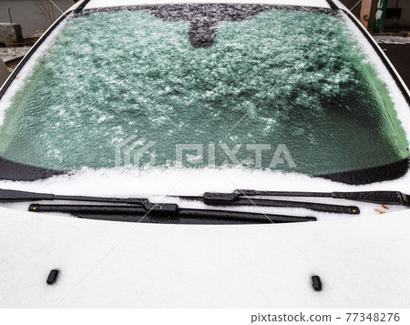 icy windshield and hood of white car close up icy windshield and hood of white car close up 77348276