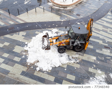 snow removal by tractor from city street 77348340