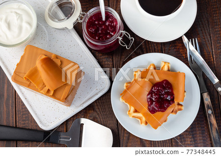 Homemade waffles with norwegian brown cheese and lingon jam, on wooden background, horizontal, top view Homemade waffles with norwegian brown cheese and lingon jam, on wooden background, horizontal, top view 77348445