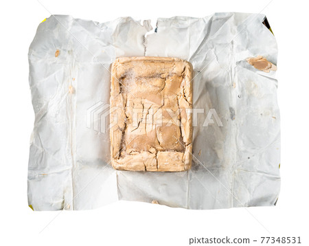 unwrapped fresh compressed yeast on foil cutout 77348531