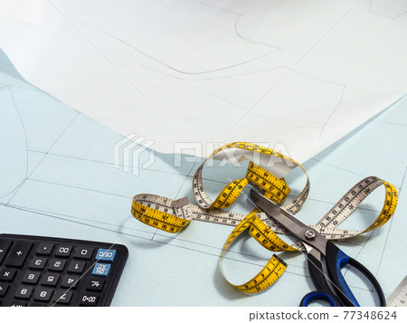 tailor's tape and scissors on paper pattern layout 77348624