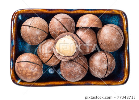 macadamia nuts with peeled seed in bowl cutout 77348715
