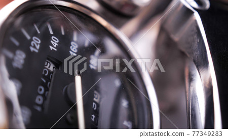 Close shot of black speedometer on the chrome painted motorcycle 77349283