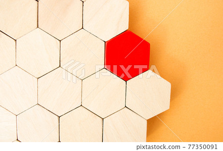 One red hexagon stands out from the rest. Leadership and victory concept. Dissimilarity and dissent. Uniqueness initiative. Superfluous, unsuitable. Going beyond. Untypical Concept 77350091